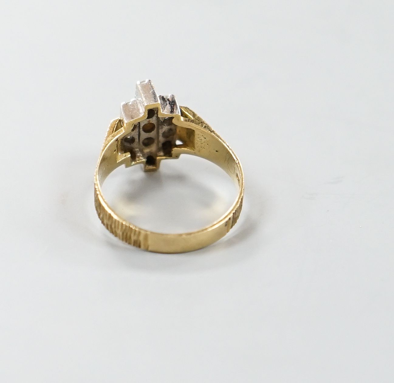 A 1970's textured 18ct gold and thirteen stone diamond set geometric dress ring, size Q, gross weight 5.3 grams.